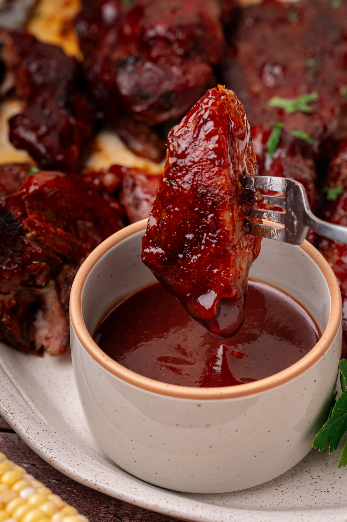 Oven baked country style ribs dipped into peach bourbon barbecue sauce