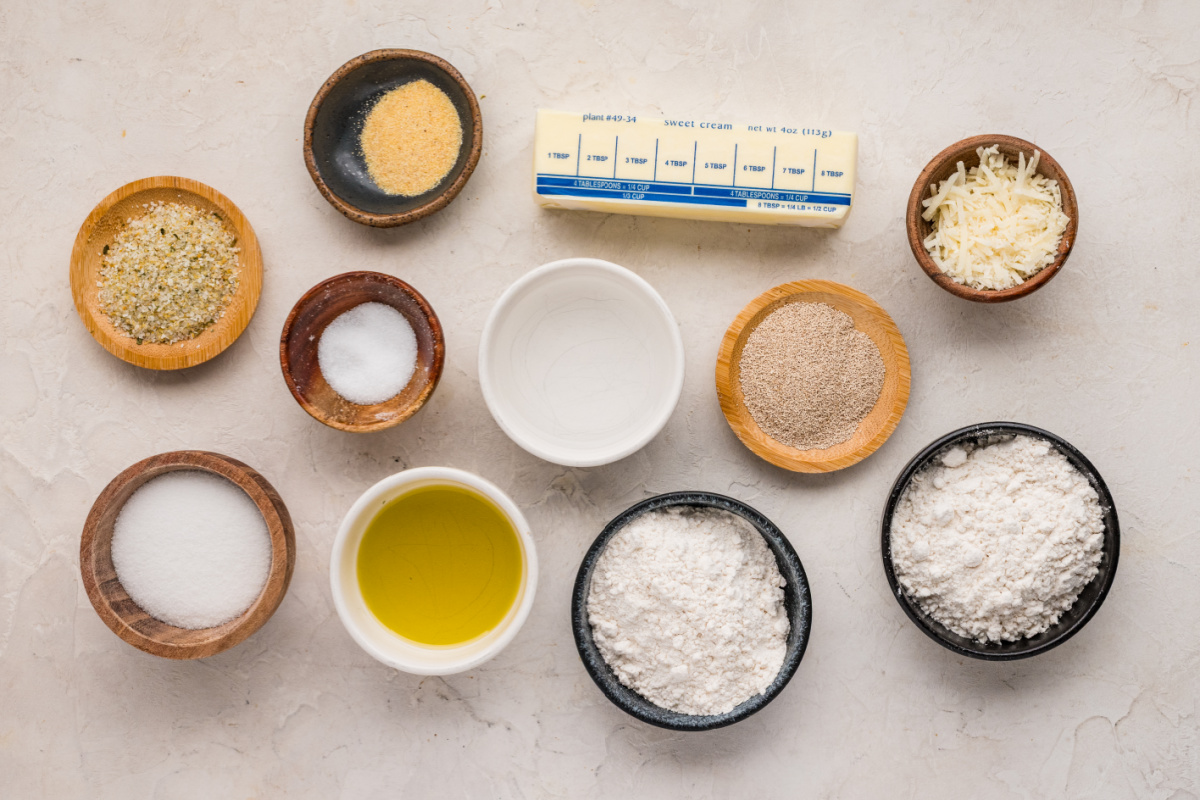 Ingredients for Parmesan bread bites including flour, yeast, Parmesan cheese, butter, olive oil, sugar, salt, and garlic powder