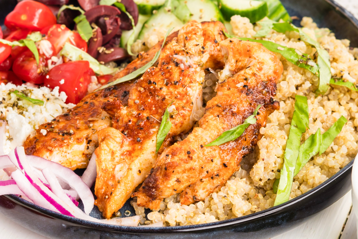 Mediterranean chicken bowl with grilled chicken, quinoa, cherry tomatoes, cucumber, feta, Kalamata olives, fresh basil, and lemon vinaigrette.