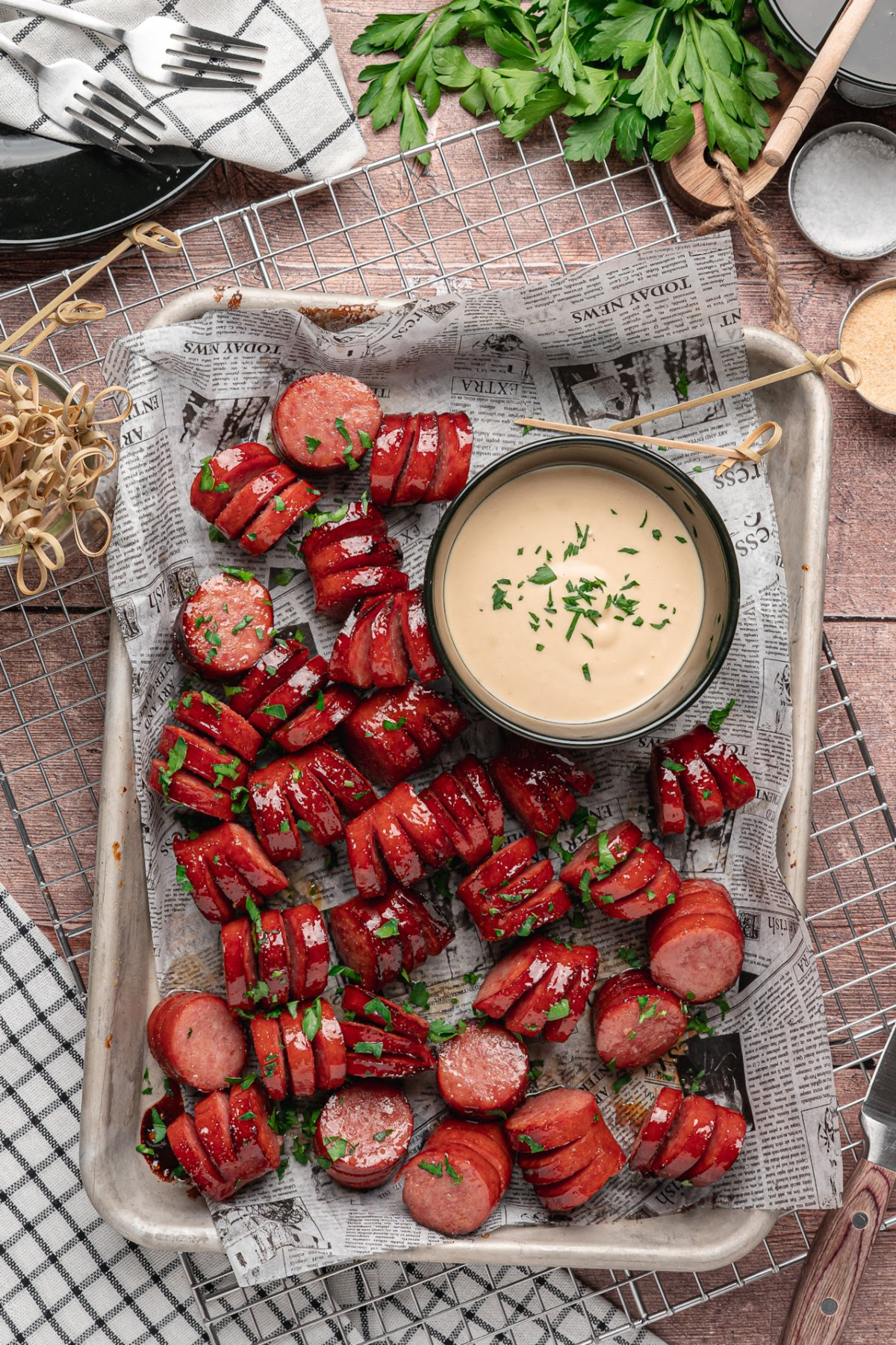 Honey garlic hasselback kielbasa bites served beside creamy honey mustard dipping sauce.