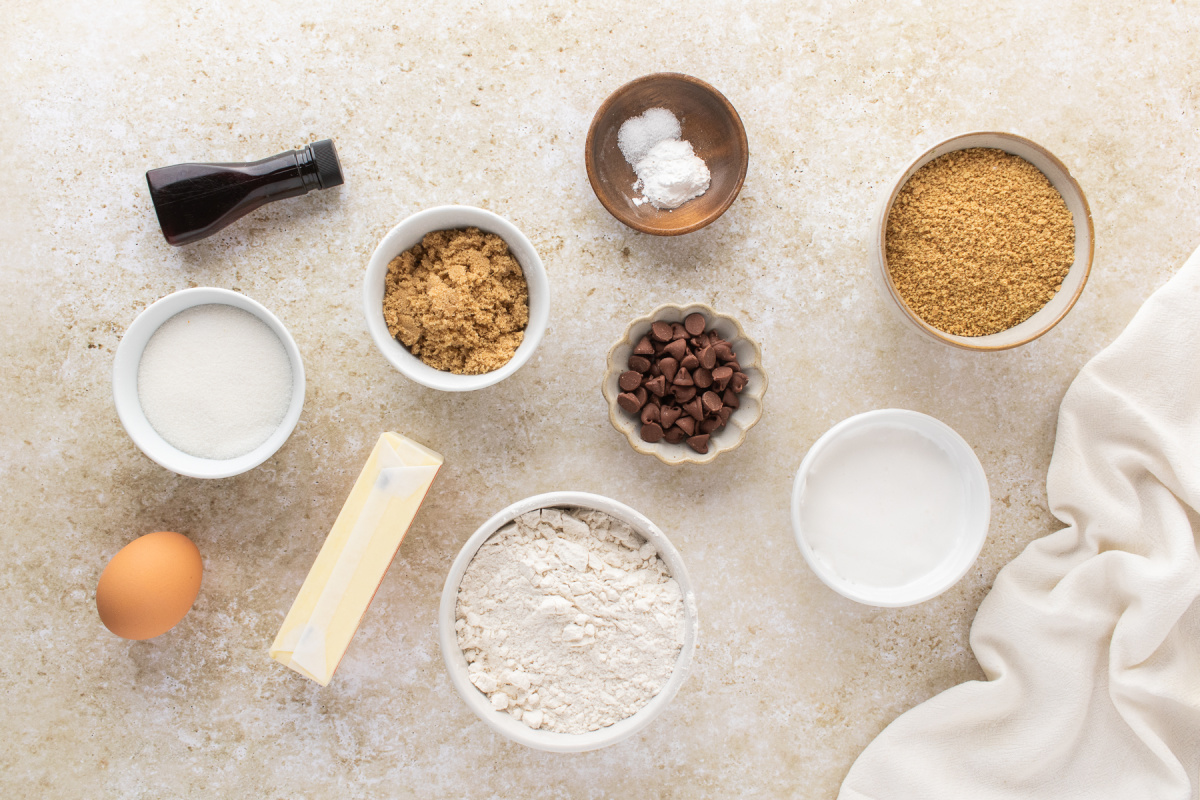 S'mores Cookie Bar Ingredients Ingredients for s'mores cookie bars including graham cracker crumbs, marshmallow creme, flour, butter, sugars, chocolate chips, vanilla, egg, baking powder, and salt.