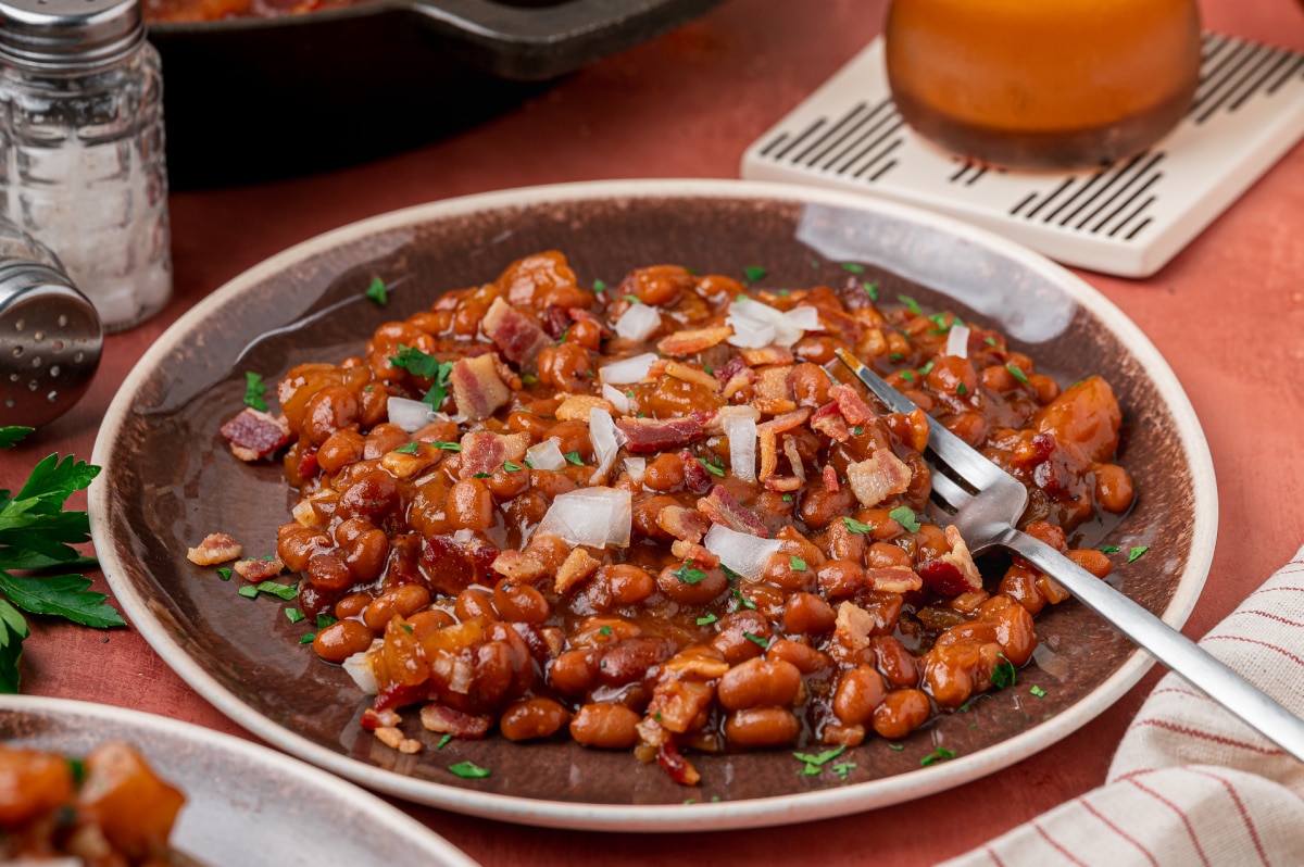 Baked Beans with Apple Pie Filling and Bacon Baked beans with apple pie filling, bacon and diced onion served on a plate
