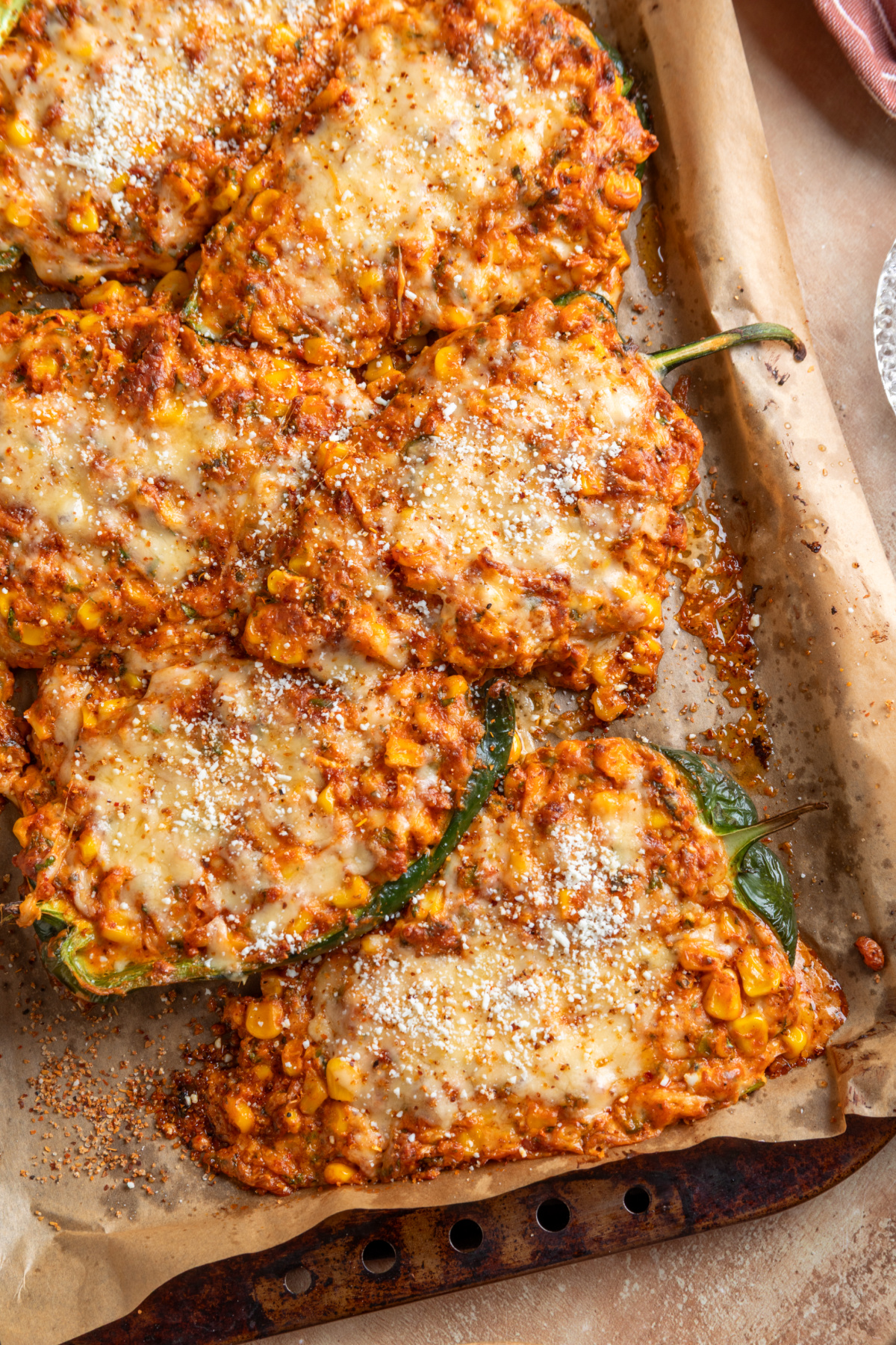 Baked Mexican street corn stuffed poblano peppers filled with chorizo and corn and topped with melted cheese, Cotija and Tajín