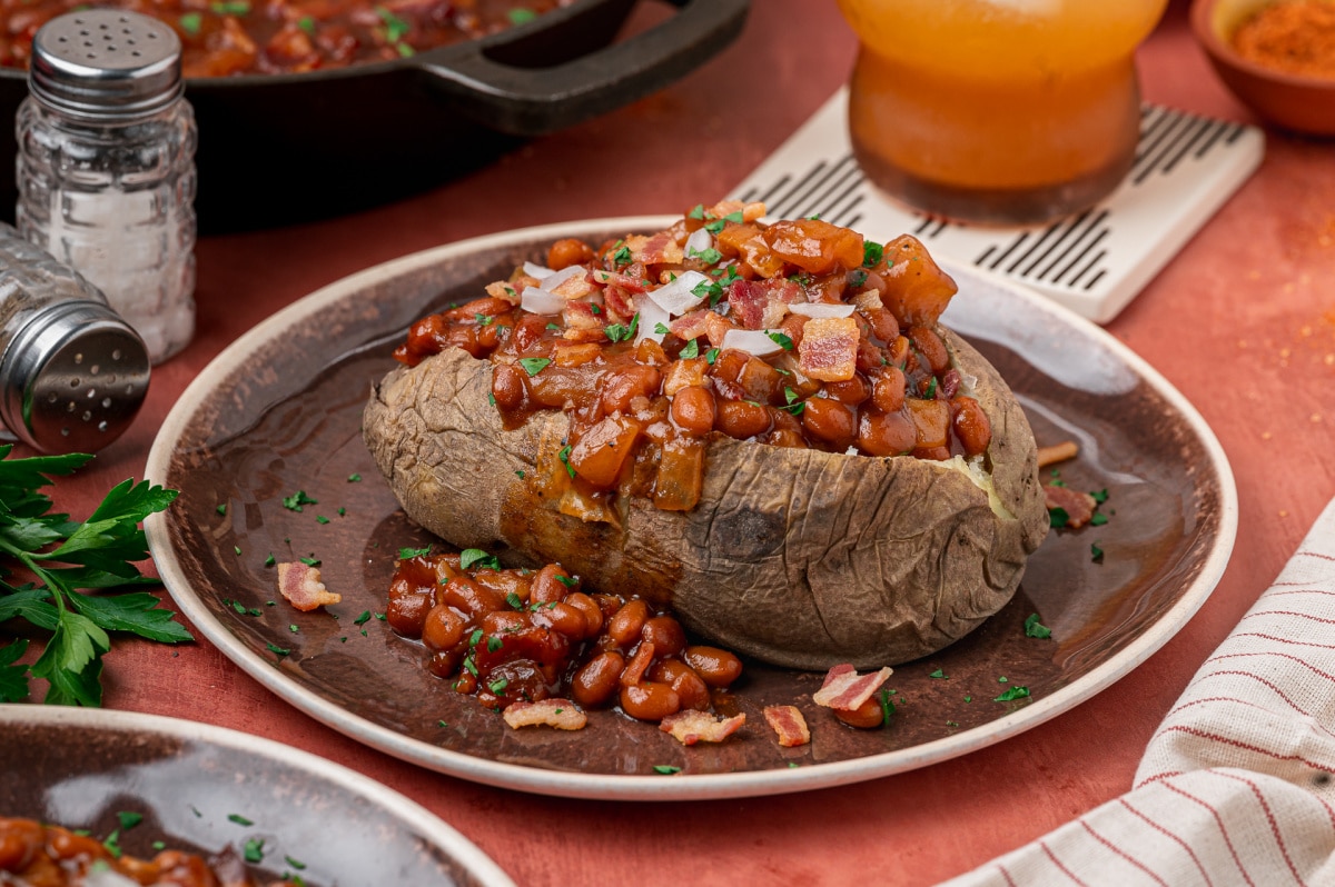 Baked Potato Topped with Apple and Bacon Baked Beans Baked potato topped with smoky baked beans, apple pieces, bacon and diced onion