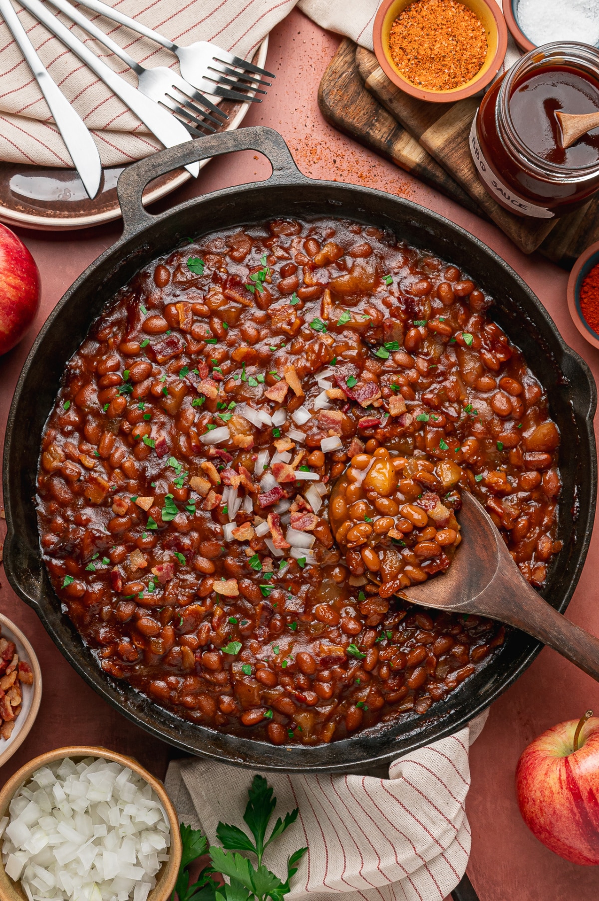 Smoky Baked Beans with Apples and Bacon Cast-iron skillet of baked beans with apple pieces, bacon and smoky barbecue sauce