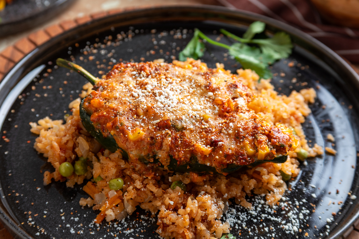 Chorizo and corn stuffed poblano pepper topped with melted cheese, Cotija and Tajín