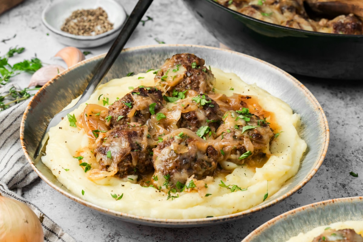 French onion meatballs in caramelized onion sauce served over mashed potatoes