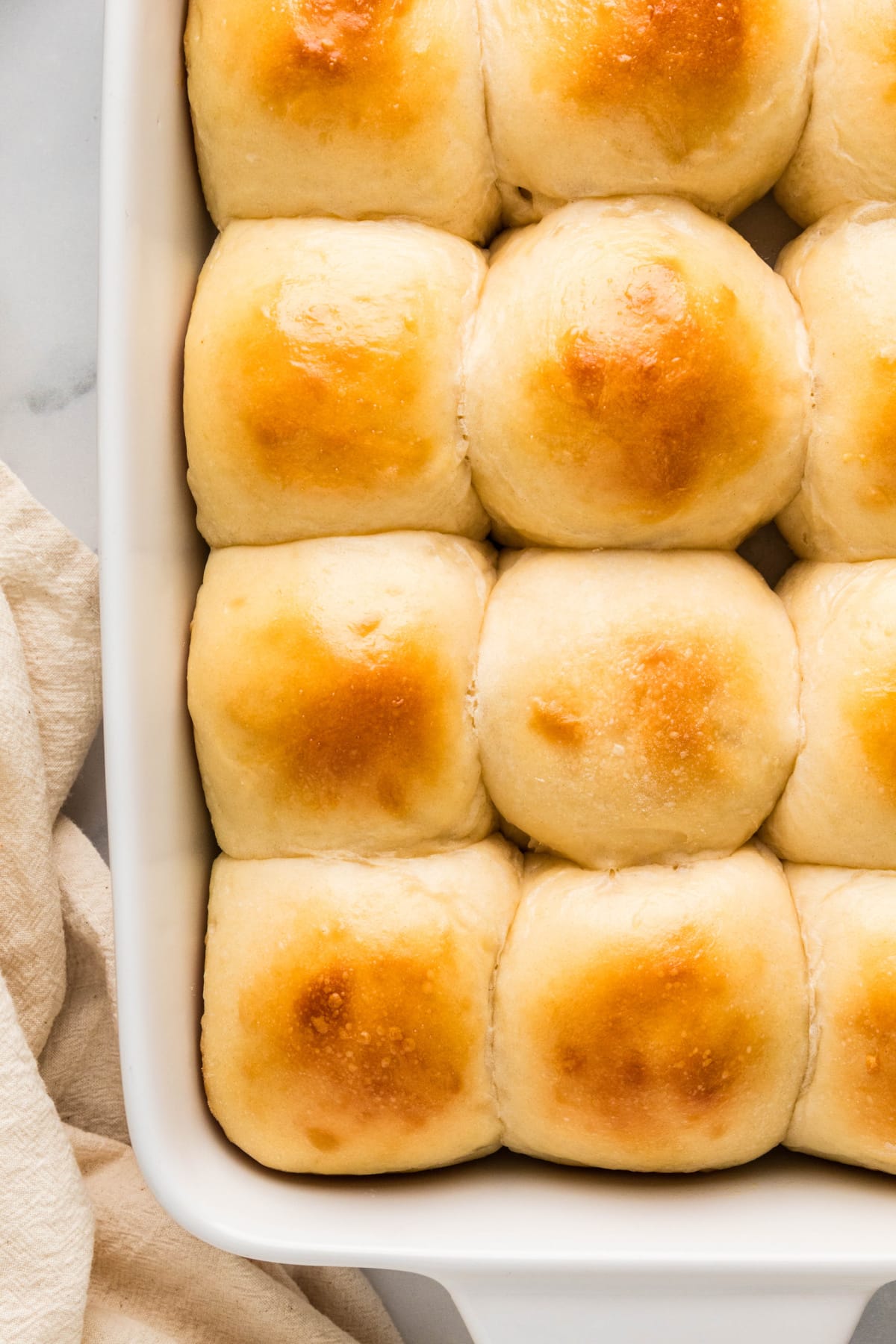 Soft pull-apart dinner rolls with golden tops Twelve golden pull-apart dinner rolls baked together with soft pale sides.