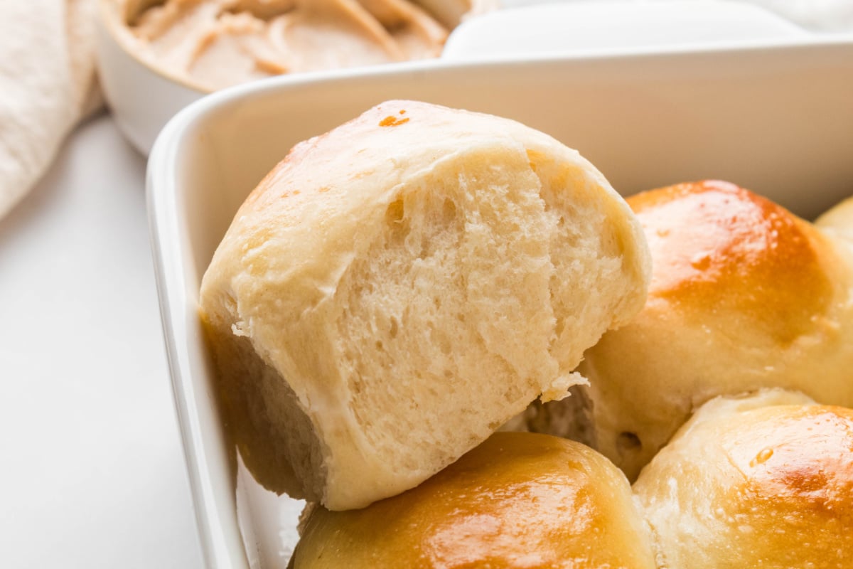 Pull-apart milk bread roll showing its soft interior Soft milk bread roll pulled from the baking dish to show the tender interior.