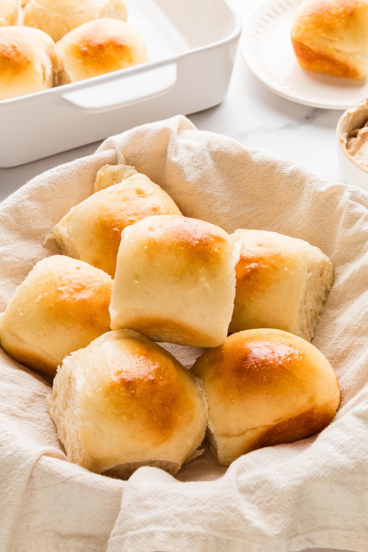 Golden pull-apart dinner rolls ready for the table Soft golden dinner rolls arranged in a cloth-lined serving basket.