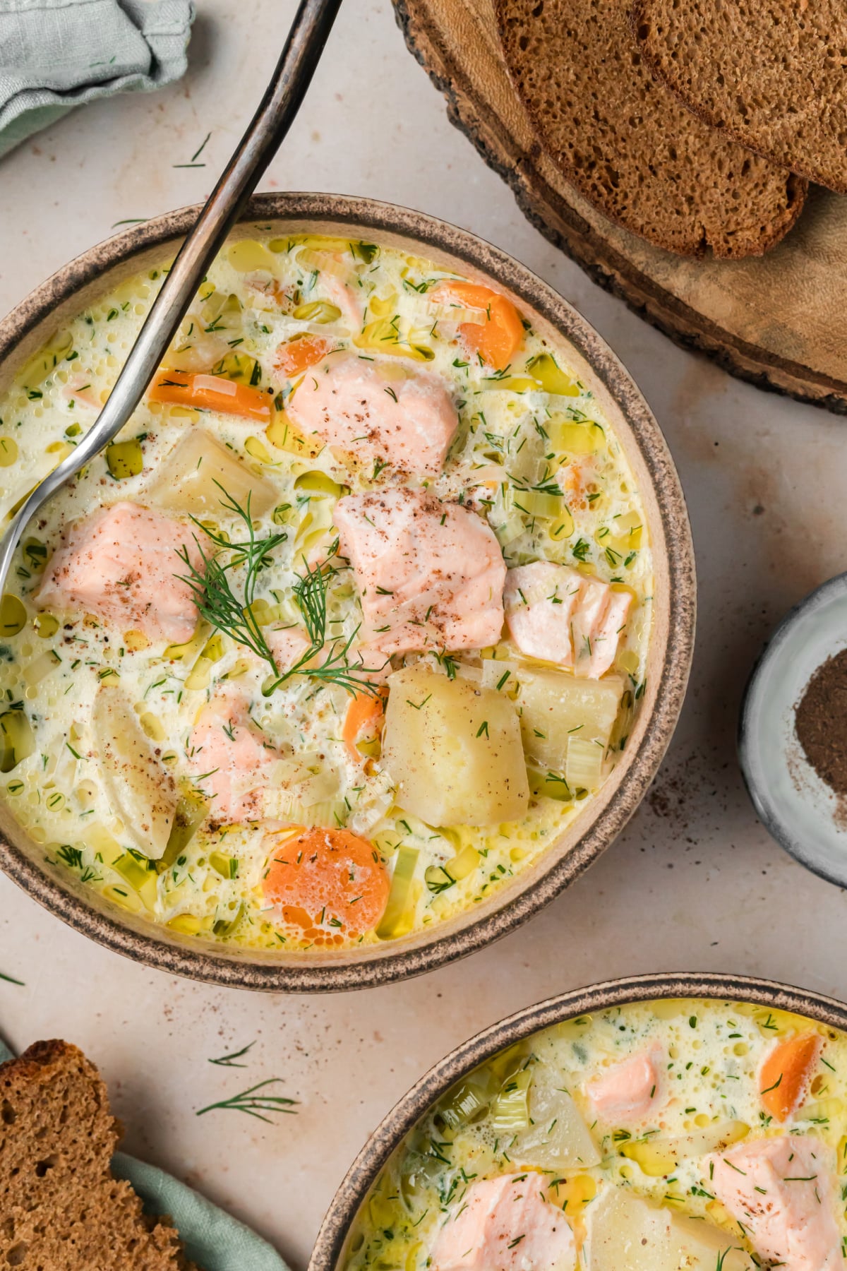 Creamy Finnish salmon soup with tender salmon, potatoes, leeks, carrots and plenty of fresh dill. Bowl of Finnish salmon soup with salmon, potatoes, carrots, leeks and fresh dill in a creamy broth.