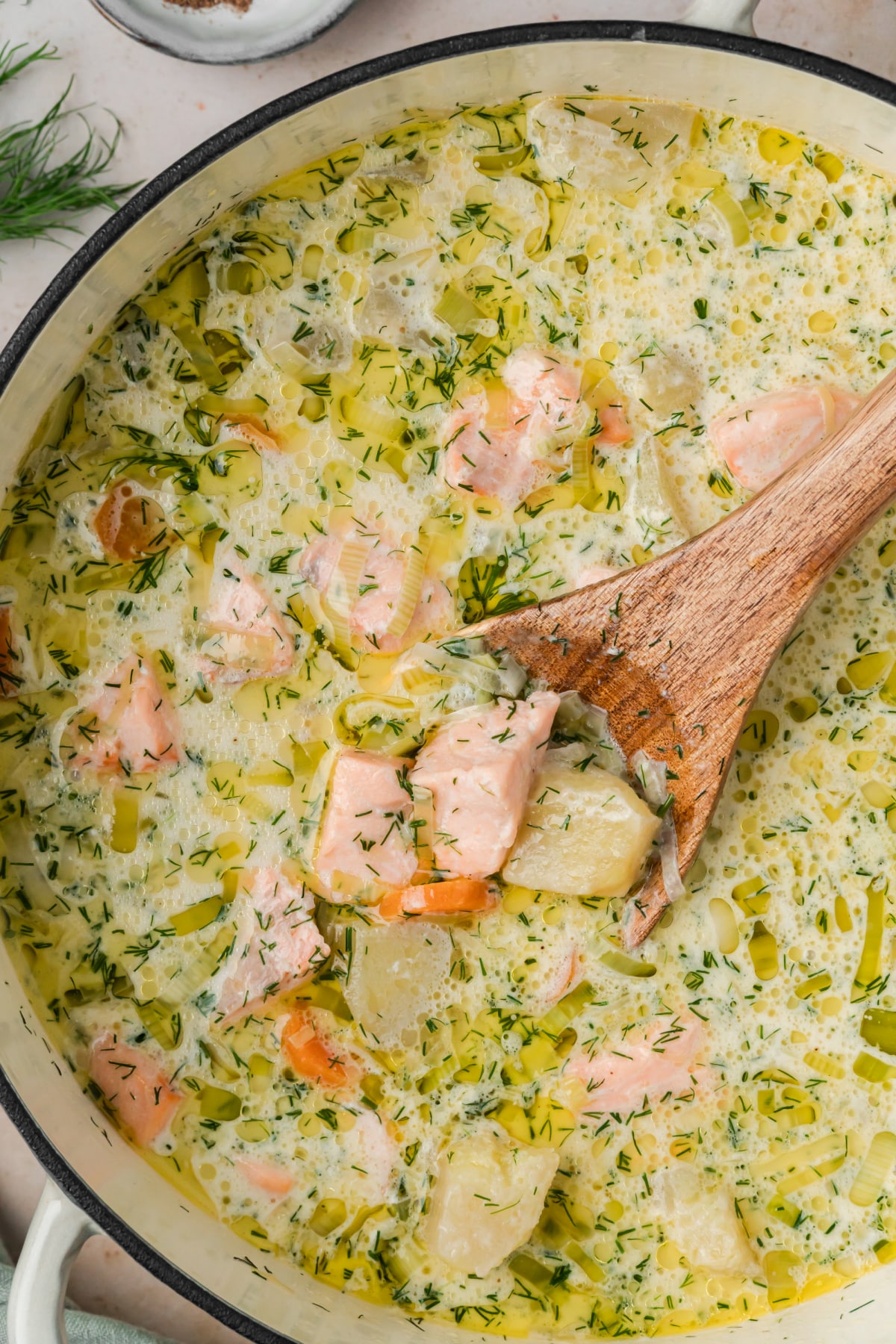 Creamy Finnish salmon soup finished with fresh dill, white pepper and allspice. Finnish salmon soup with tender salmon, potatoes, leeks, carrots, cream and fresh dill in a Dutch oven.