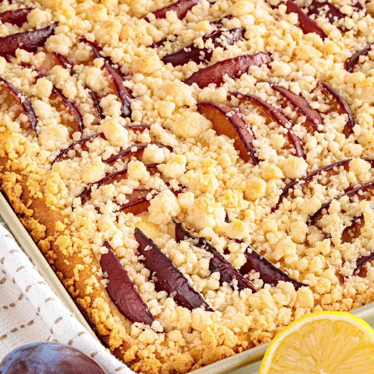 German plum cake with buttery cinnamon streusel and sliced Italian prune plums baked in a sheet pan.