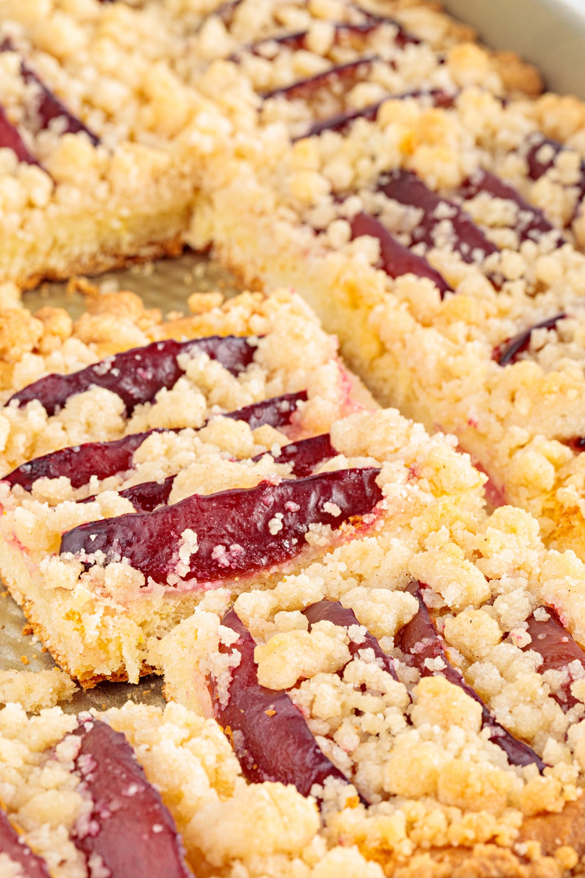 Plum Streusel Cake Slices Close-up of sliced plum streusel cake showing baked plums, buttery streusel and the soft yeasted cake underneath.
