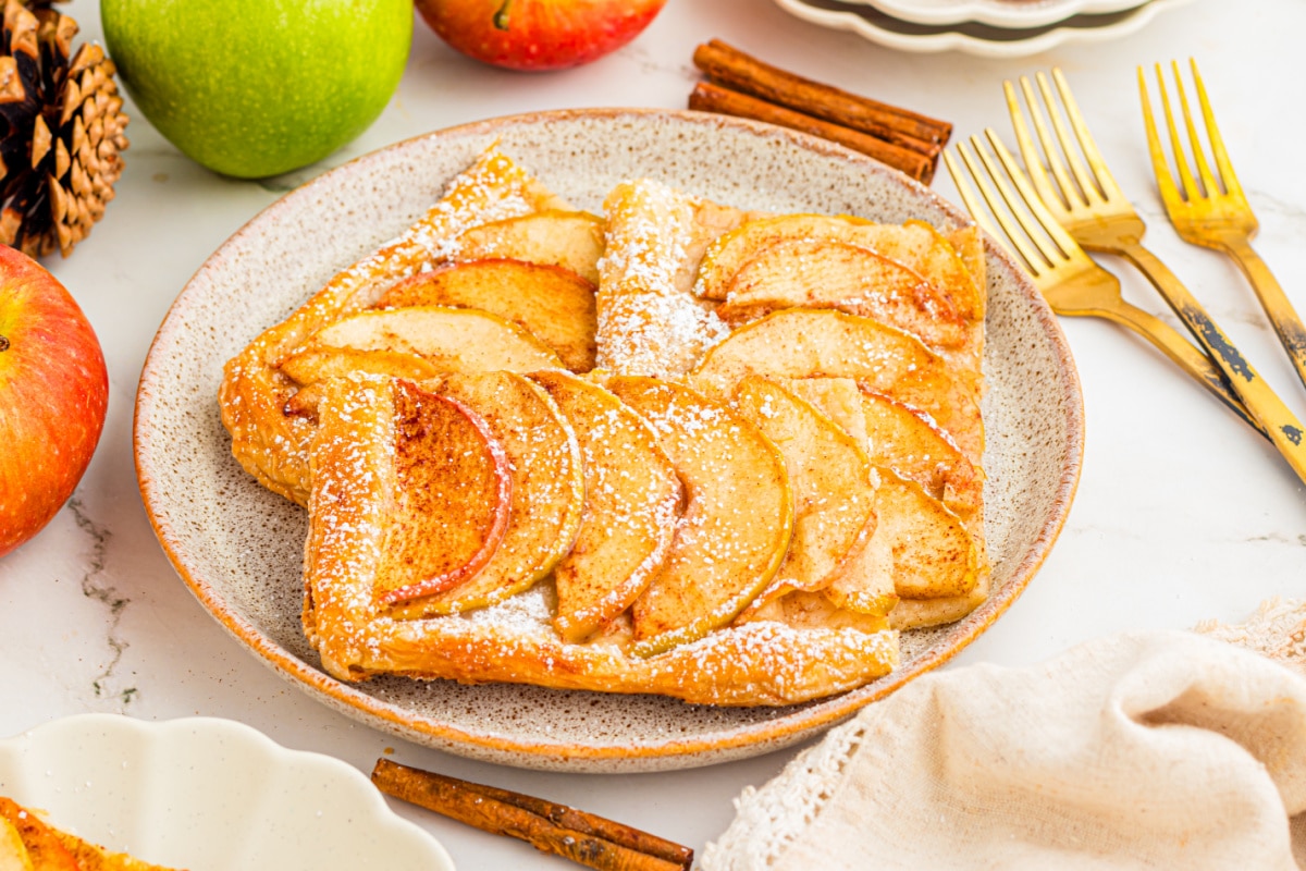 Slices of puff pastry apple tart topped with cinnamon apples and powdered sugar