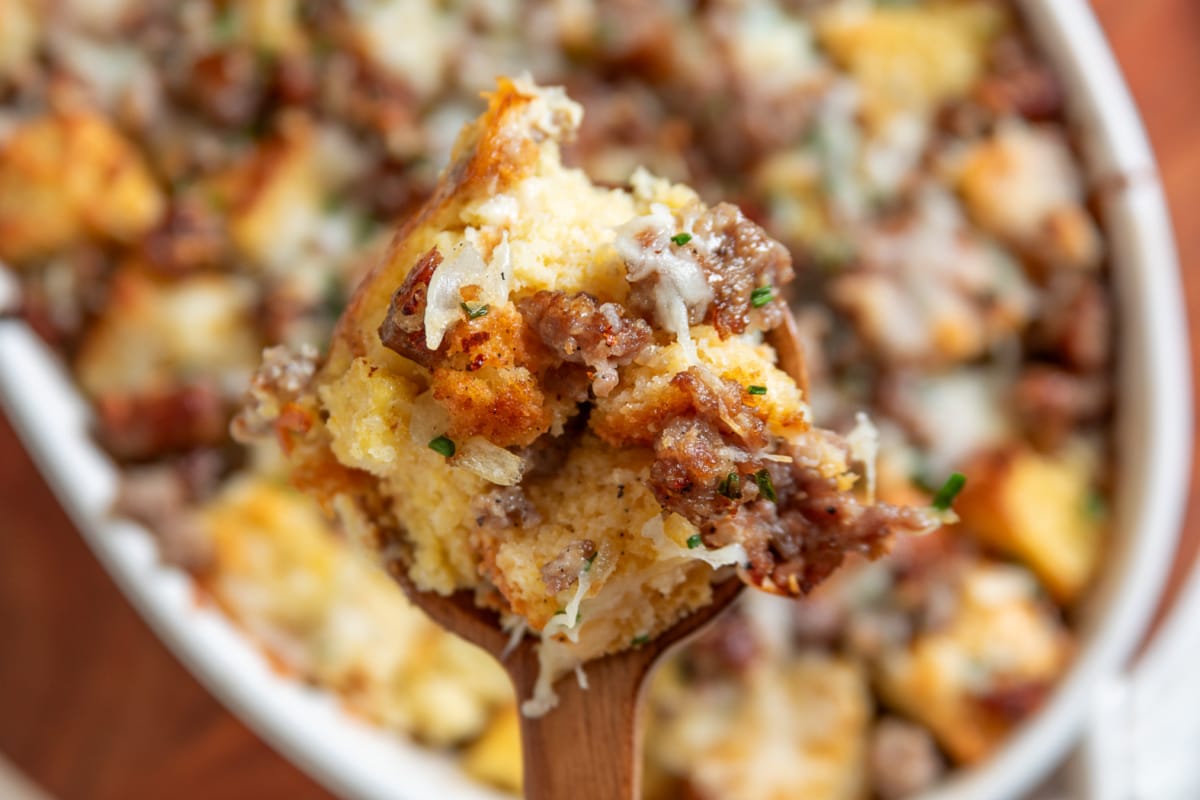 Spoonful showing cornbread chunks, sausage and melted cheese Spoonful of cornbread breakfast casserole with sausage, melted cheese and chives