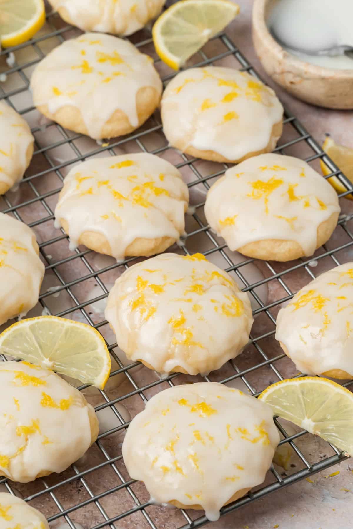 Glazed Ricotta Cookies with Fresh Lemon Zest Soft ricotta cookies covered with lemon glaze and fresh lemon zest on a cooling rack