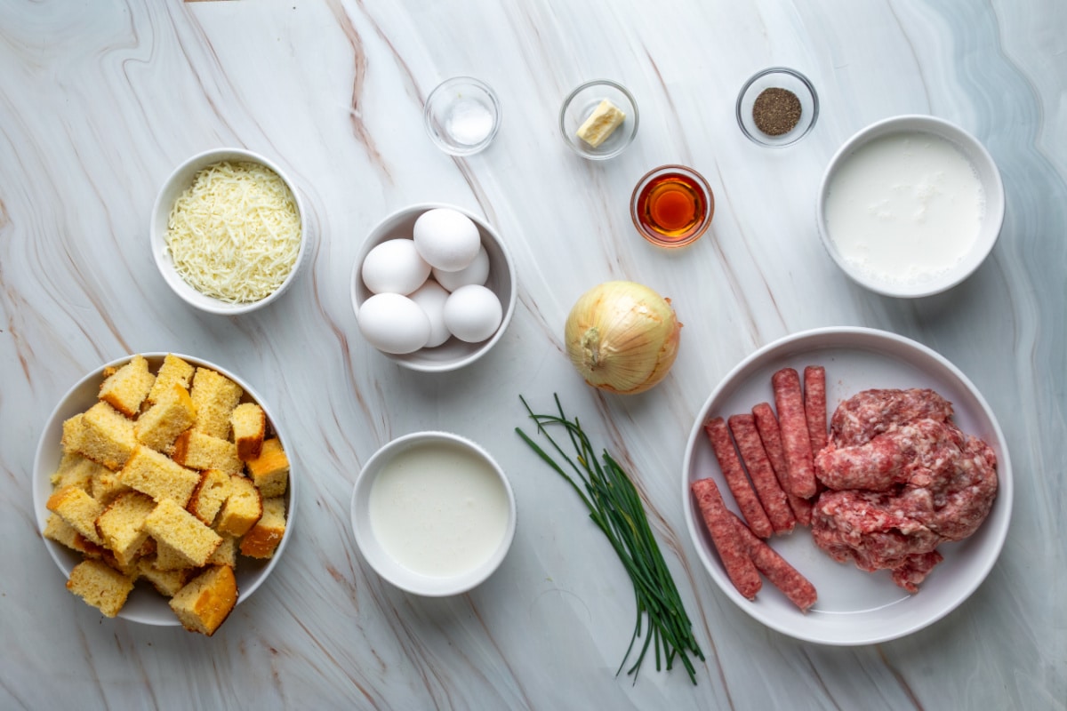 Cornbread breakfast casserole ingredients with maple sausage, eggs and cheese Ingredients for leftover cornbread breakfast casserole with two kinds of sausage, eggs, cheese and chives